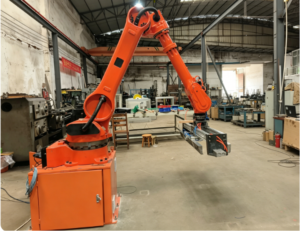 An orange JinXi collaborative robotic arm operates in a modern, high-tech factory environment without safety fences, demonstrating its unique collision detection and human-machine collaboration capabilities